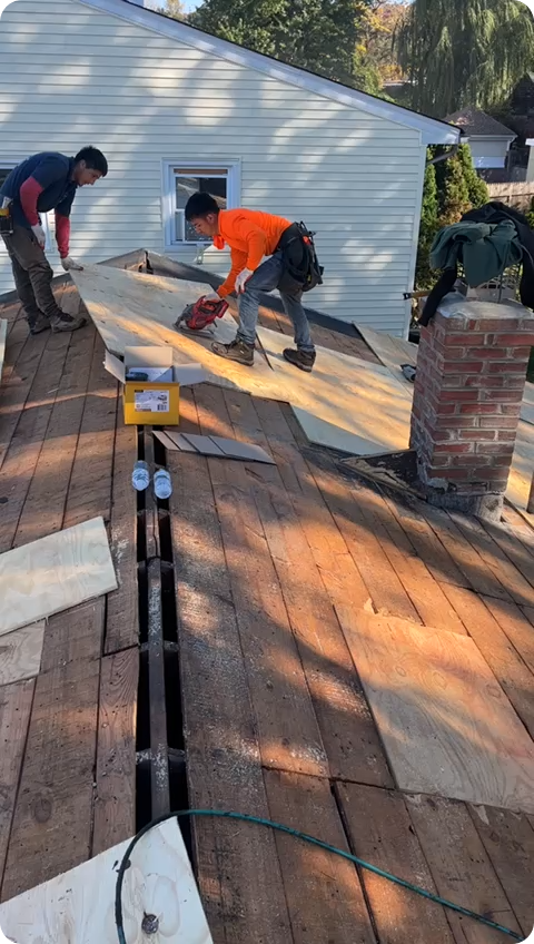 Roofing experts working in top a roof in a house in New Jersey. Roofing experts working in top a roof in a house in New Jersey.